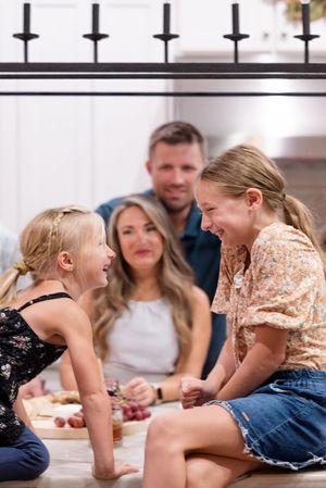 A happy family shares a joyful moment together while sitting on the floor at home.
