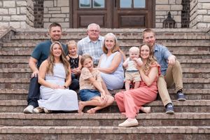 Family portrait session on stone steps showing casual group poses against architectural backdrop.