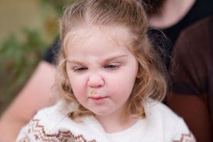 Sweet candid moments shared between family members in an outdoor setting with natural lighting.