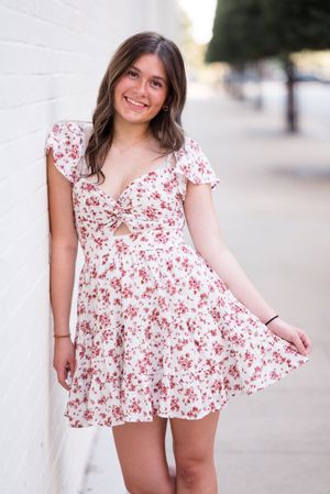 A series of four photos showing a person in a white and red floral print dress twirling and posing against a light background.