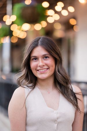Portrait with bokeh lights and cream colored top creating warm ambiance.