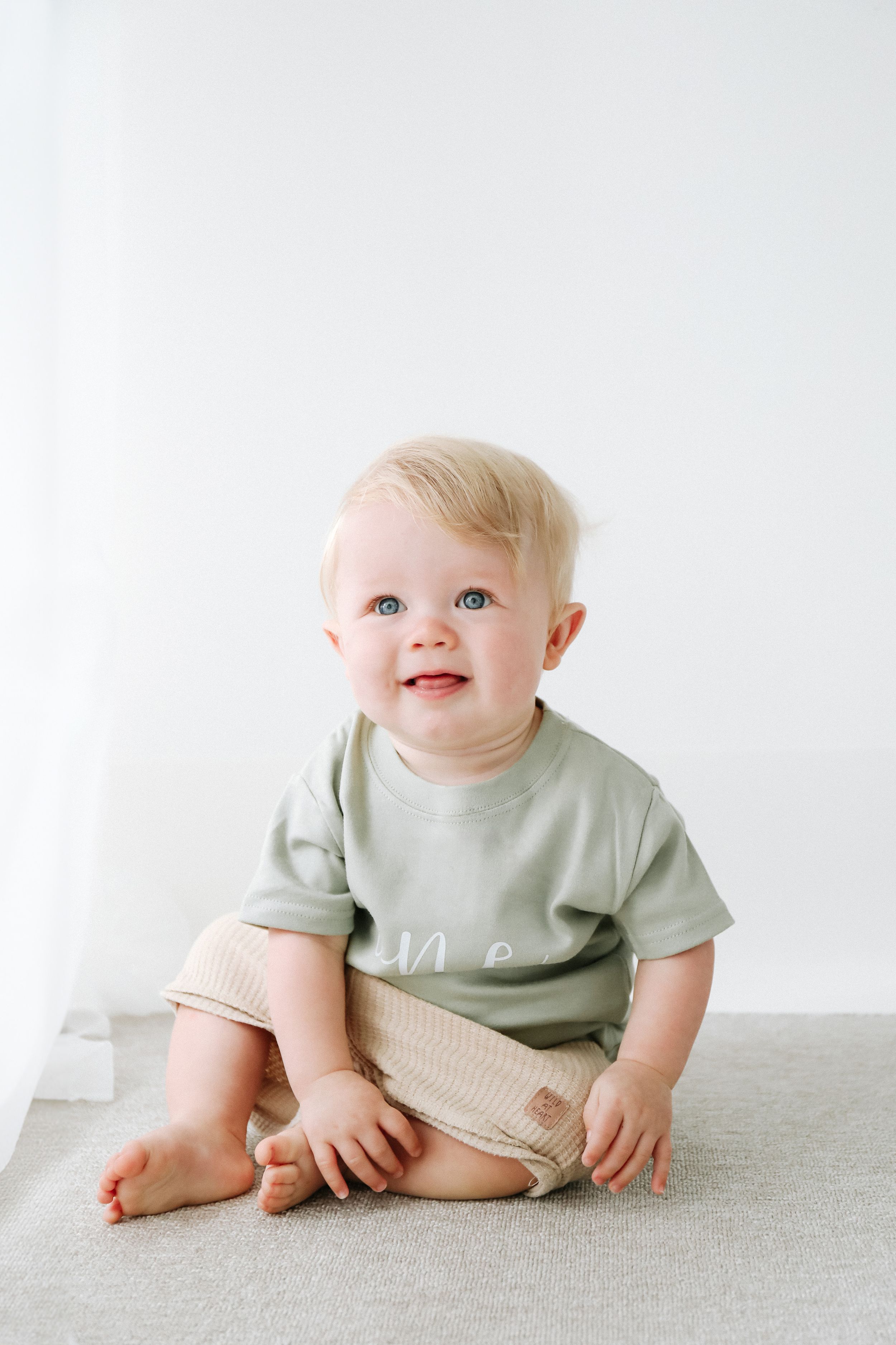 First birthday photographer Nottingham smiling neutral background cosy studio