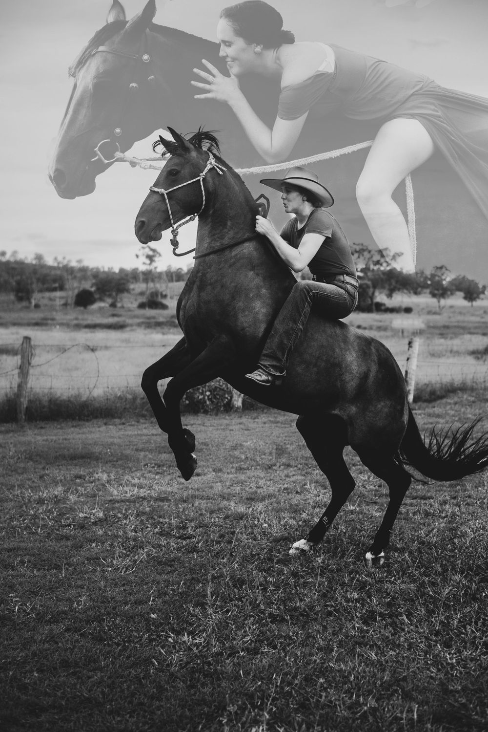 A black and white photo of two people performing stunts on a dark horse in a field.