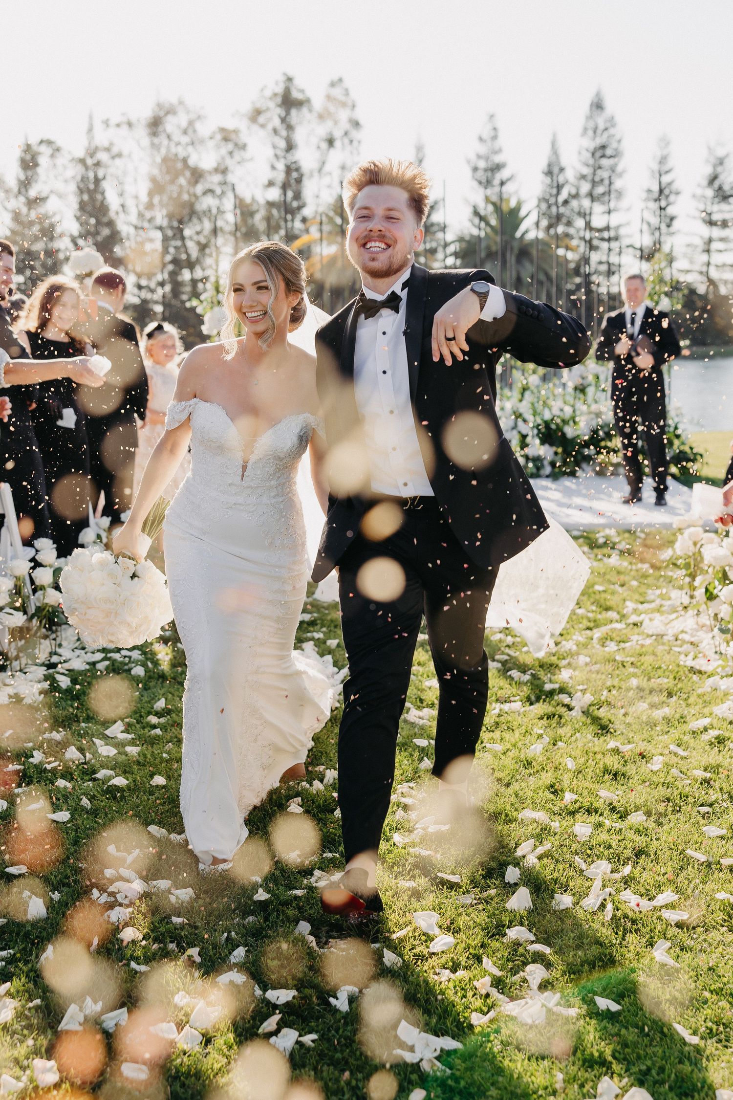 Newlyweds celebrate with energetic dance moves during outdoor wedding ceremony.