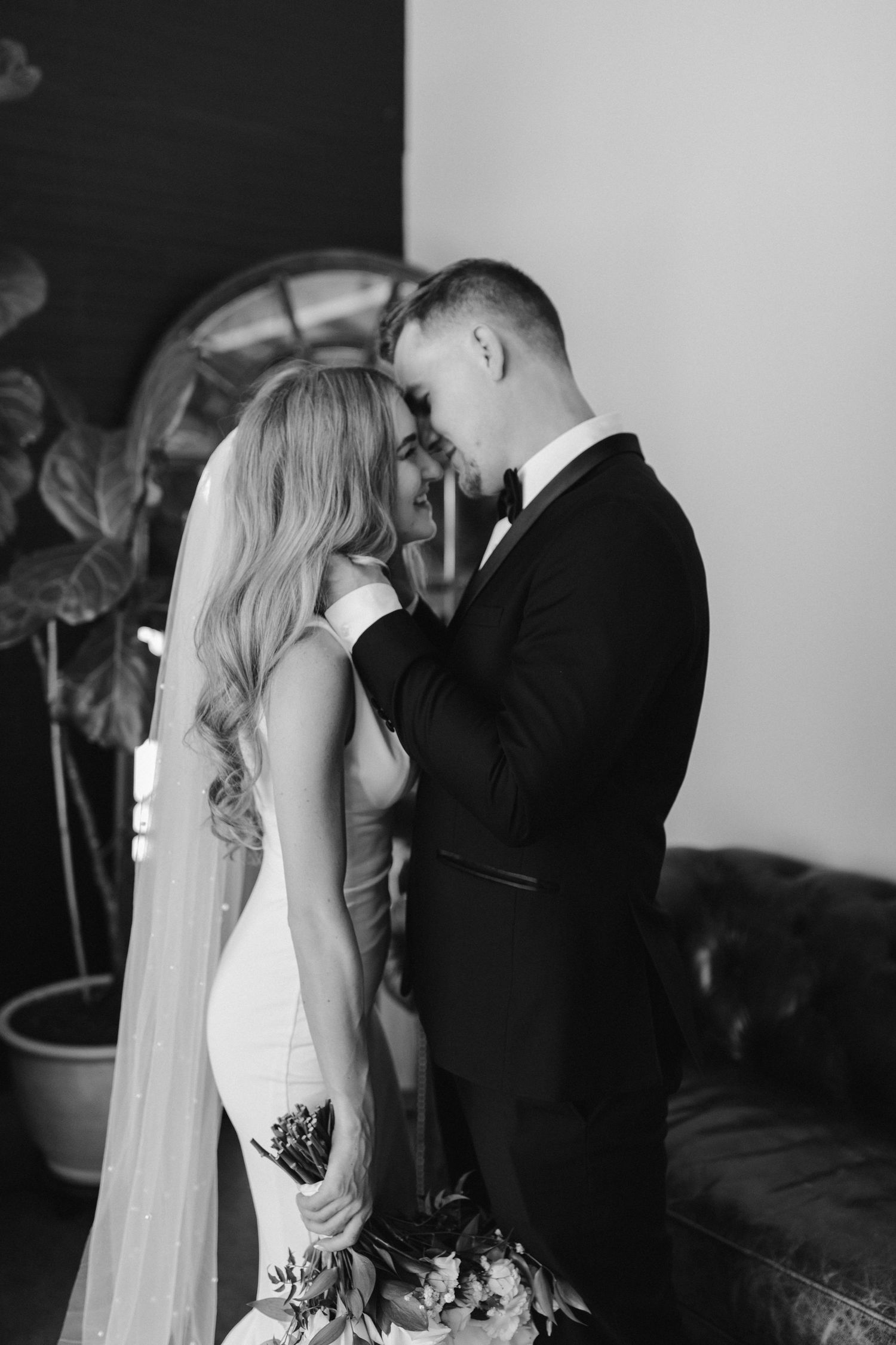 Intimate black and white wedding moment against modern interior backdrop.