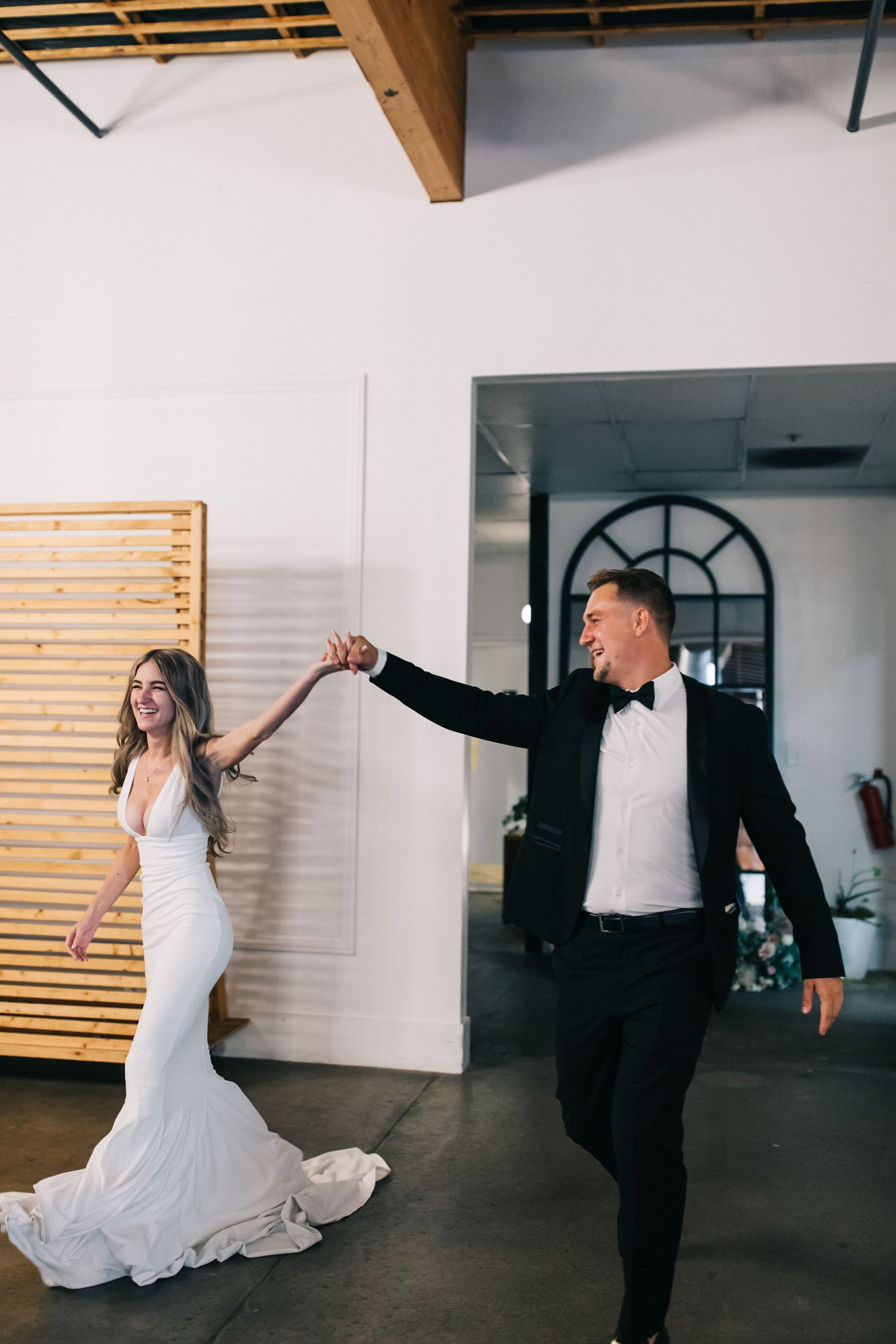 Newlyweds dancing and twirling in a modern industrial venue.