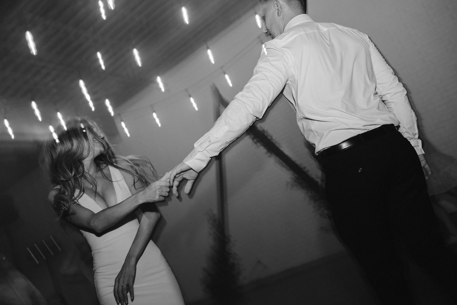 Black and white photo captures dynamic dancing movement at evening celebration.