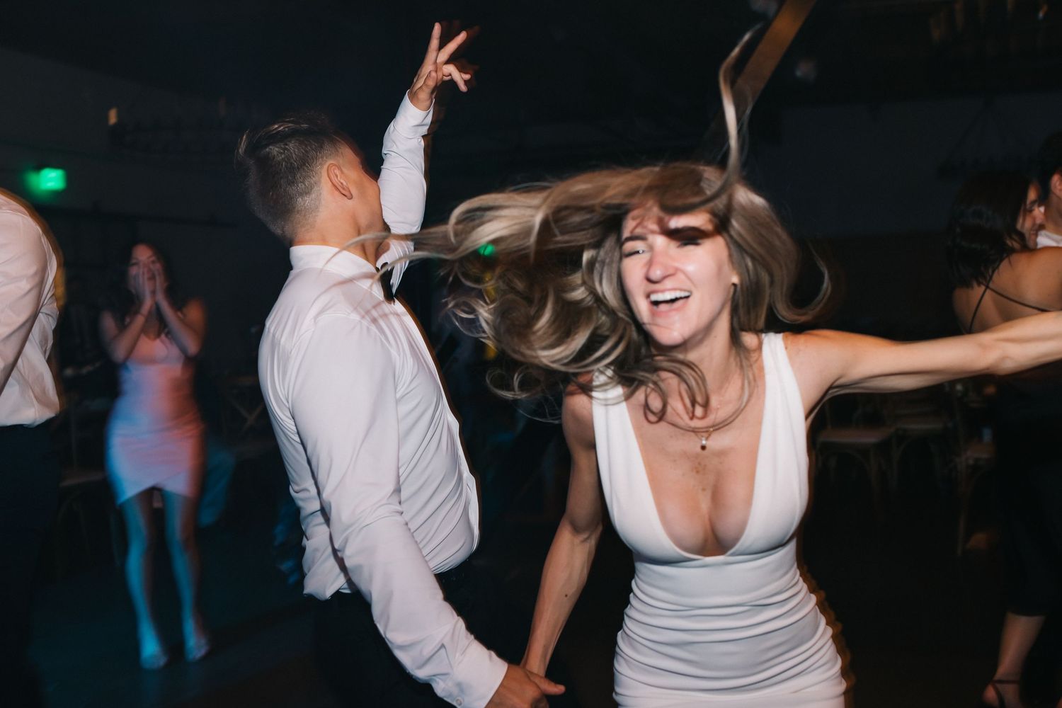 Energetic dance moves captured during lively wedding reception party.