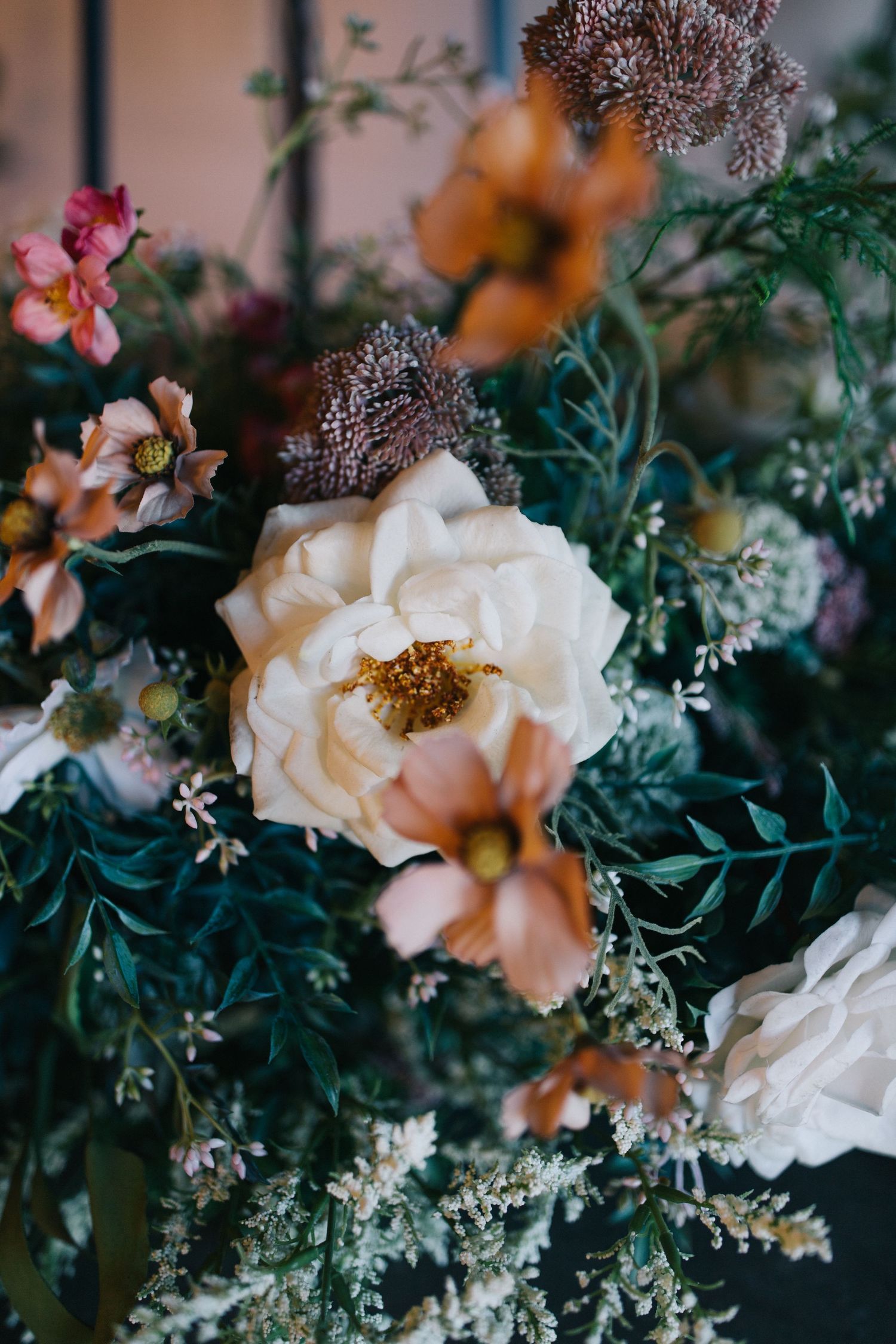 Delicate white and pink floral arrangement with roses and greenery in romantic vintage style.