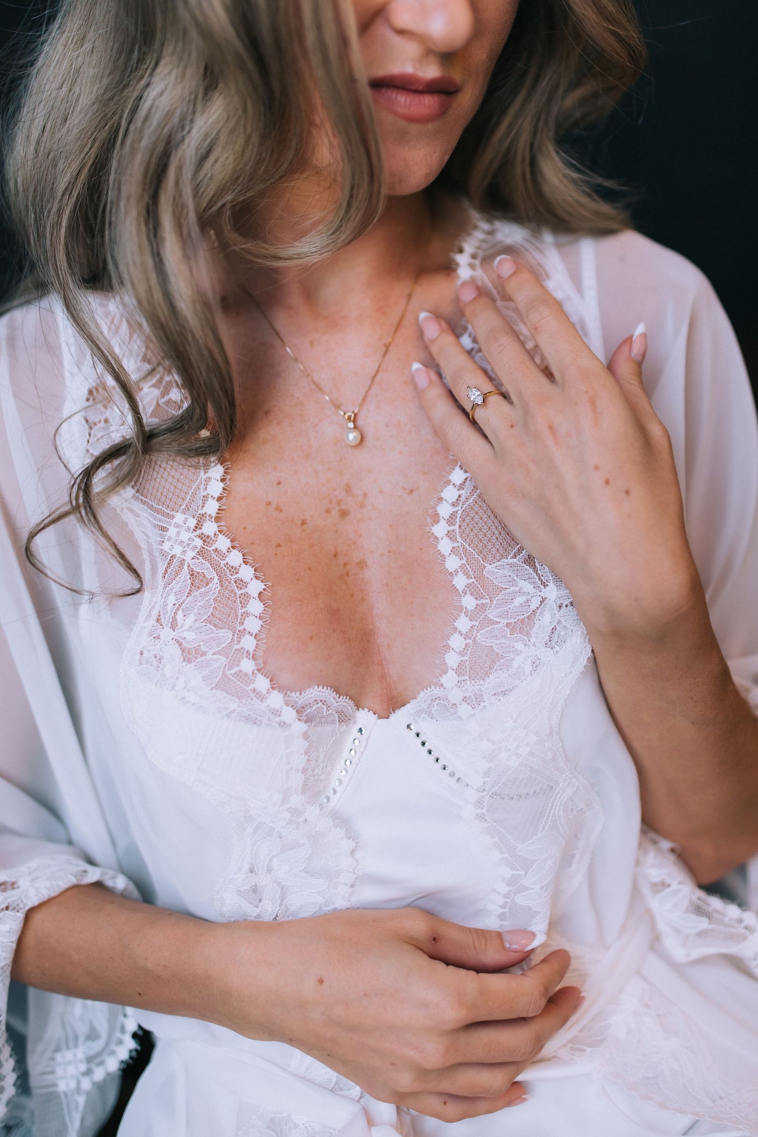 Delicate white lace robe with pearl necklace detail.