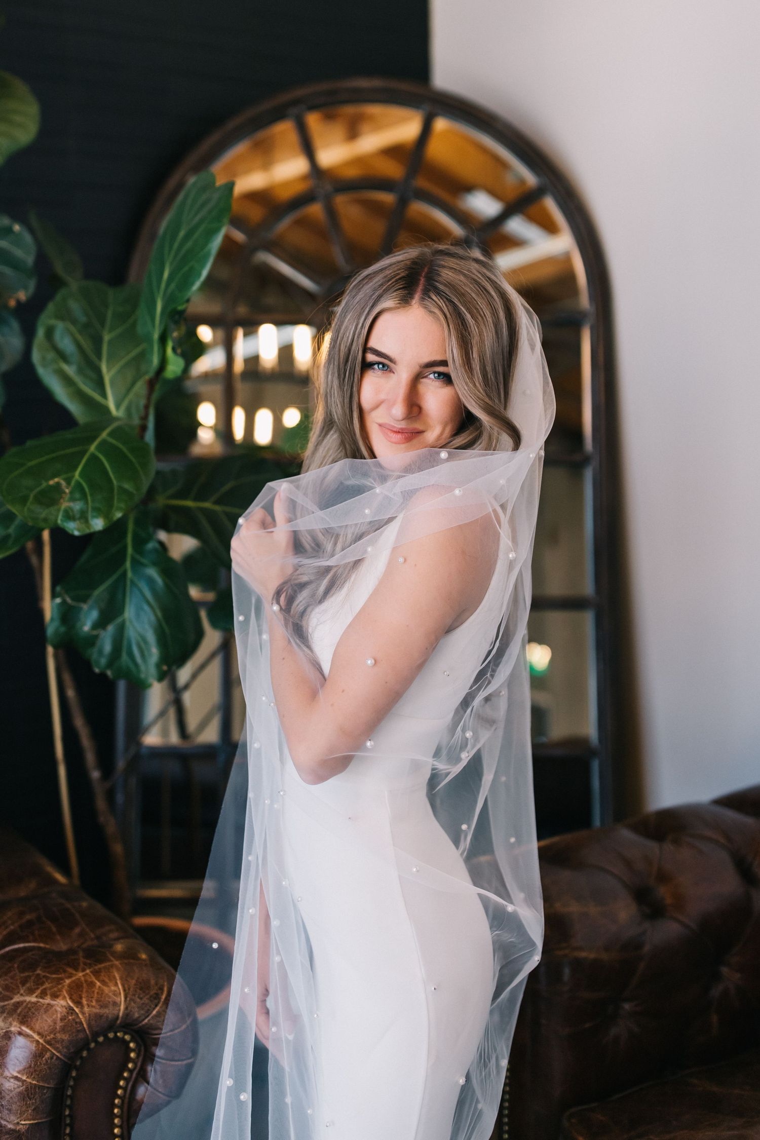 A bridal portrait with soft lighting and an arched mirror backdrop.