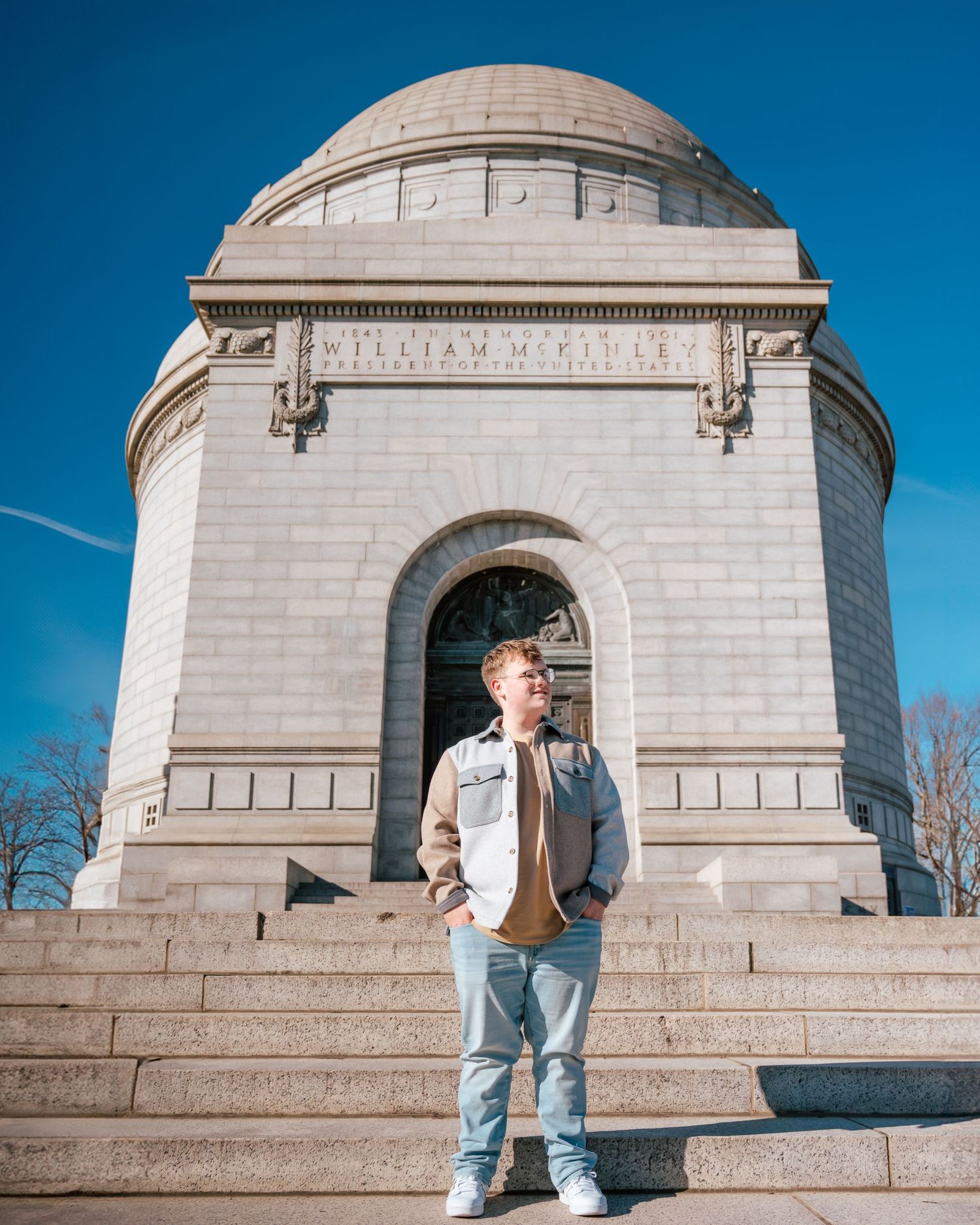 A young man poses confidently on the steps of the William McKinley Presidential Memorial.