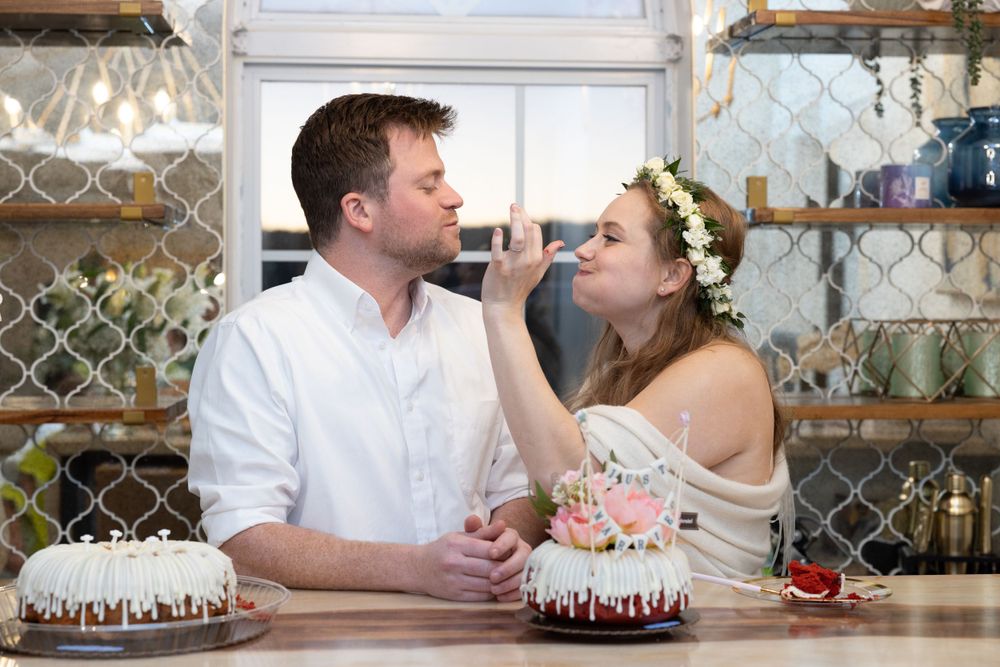 A couple sharing dessert and smiling at table with cakes.
