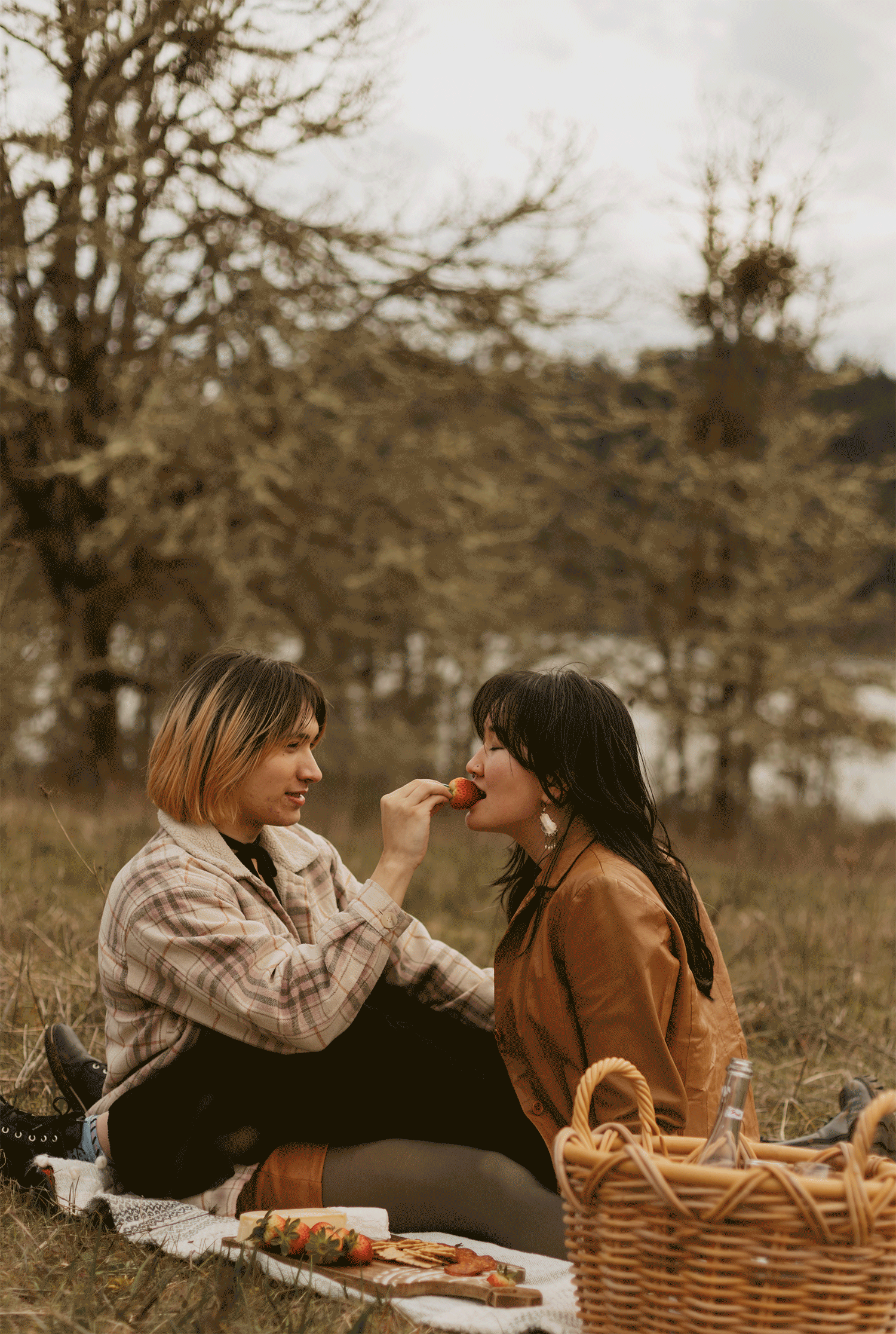 GIF of couple sharing a strawberry from their picnic.