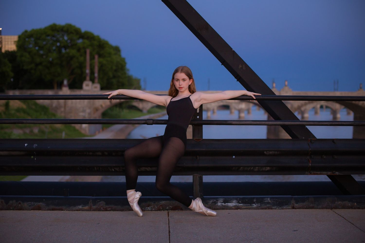 Dancer posed on an iron truss bridge at dusk in Harrisburg