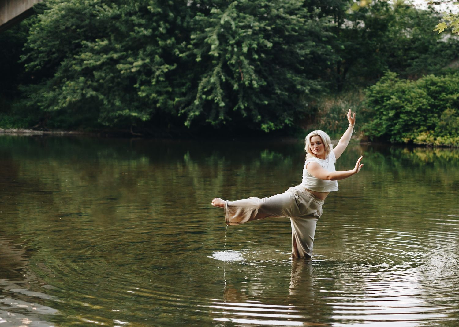 Dancer balancing on one leg in a still pond in Lemoyne