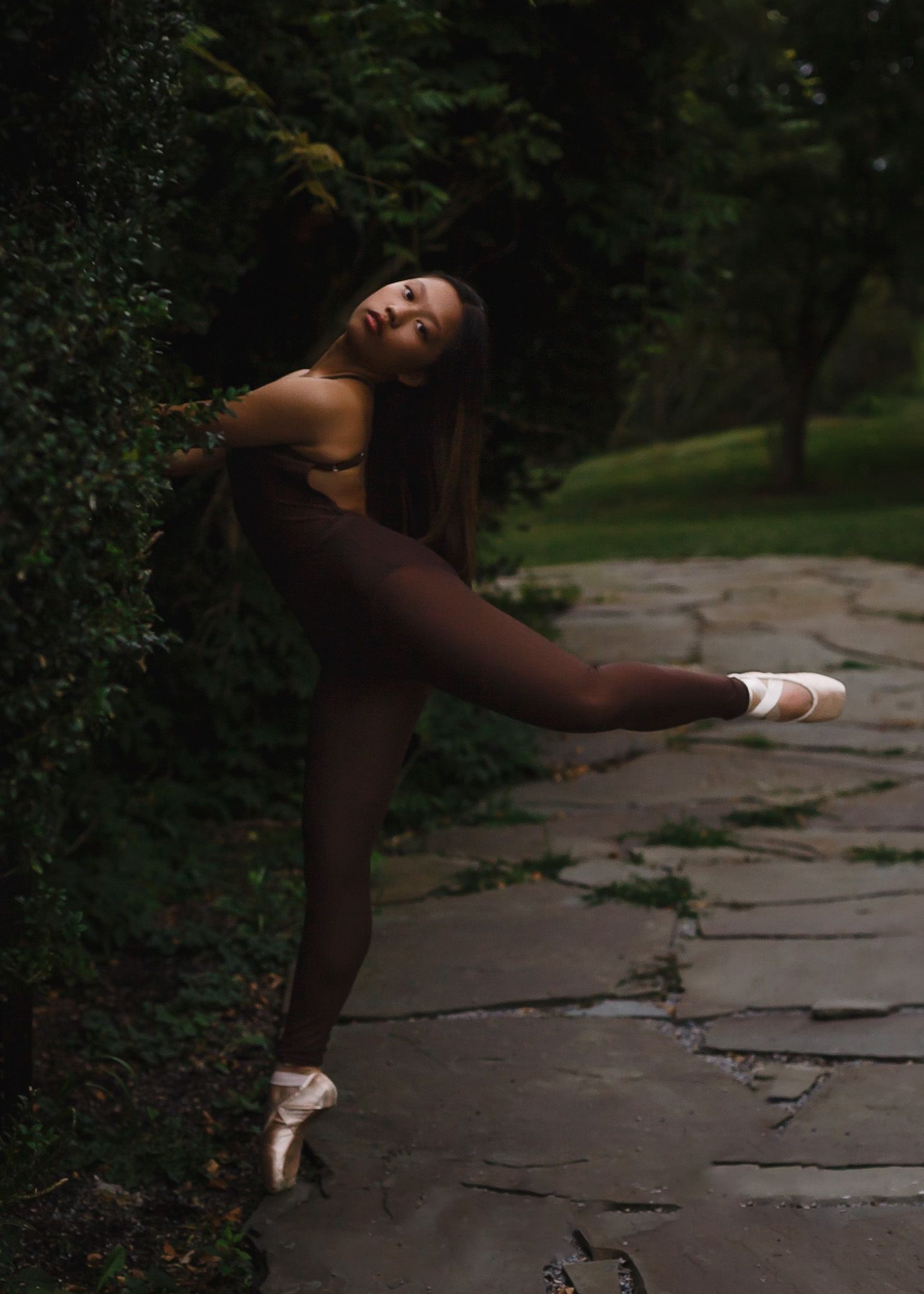 Dancer in arabesque on a garden stone path during a Central PA session