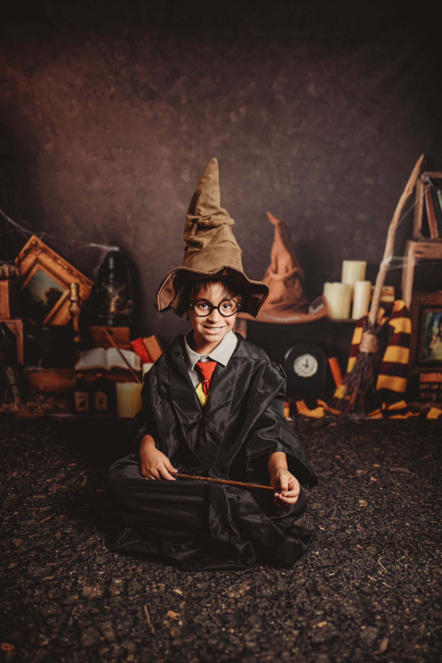 A magical themed photo session with wands and mystical props against a dark backdrop.