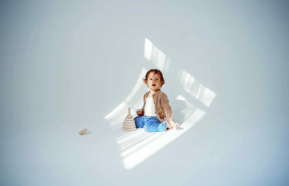 Natural light streaming through windows creates dramatic shadows on white floor.