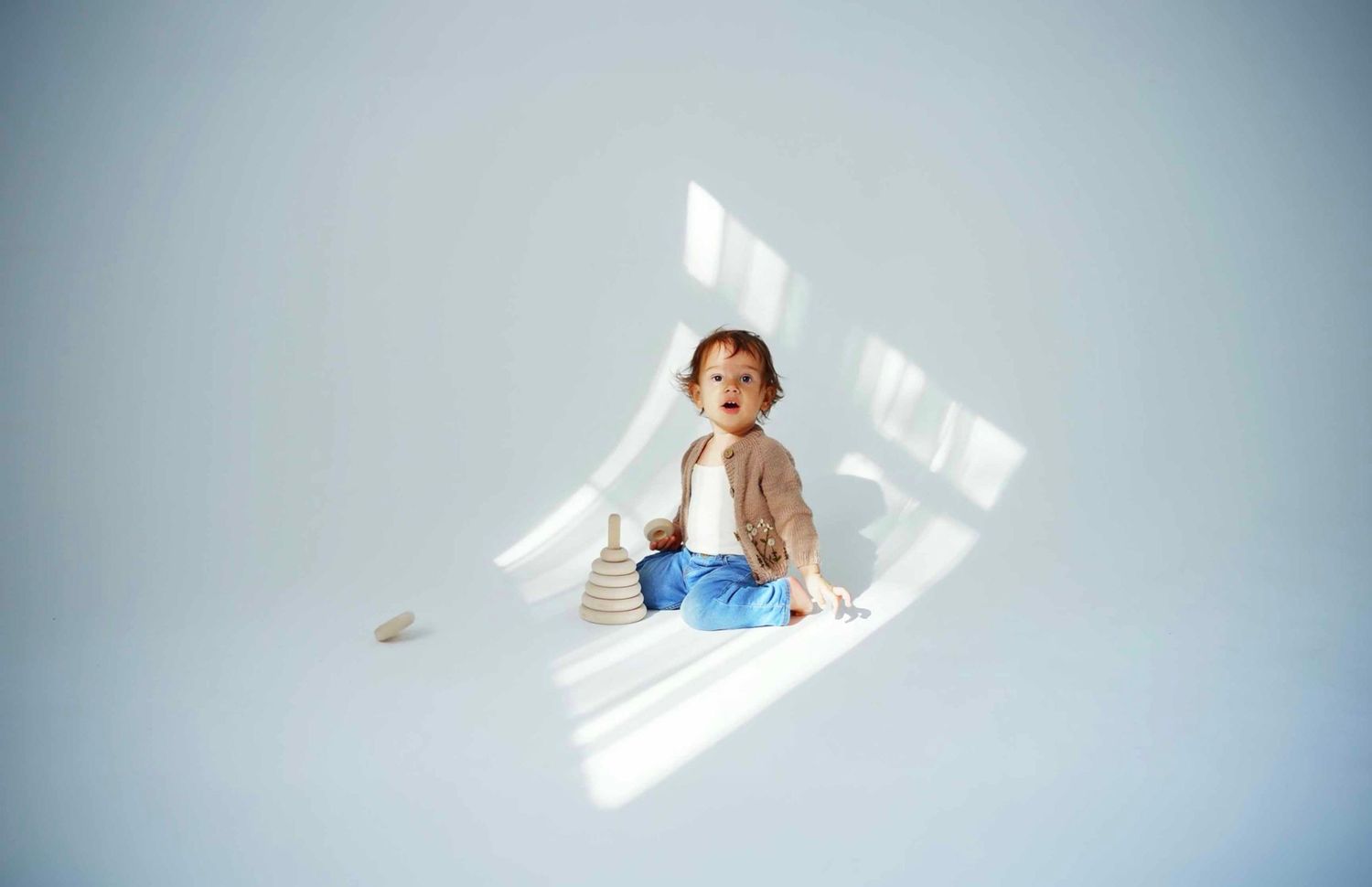 Natural light streaming through windows creates dramatic shadows on white floor.