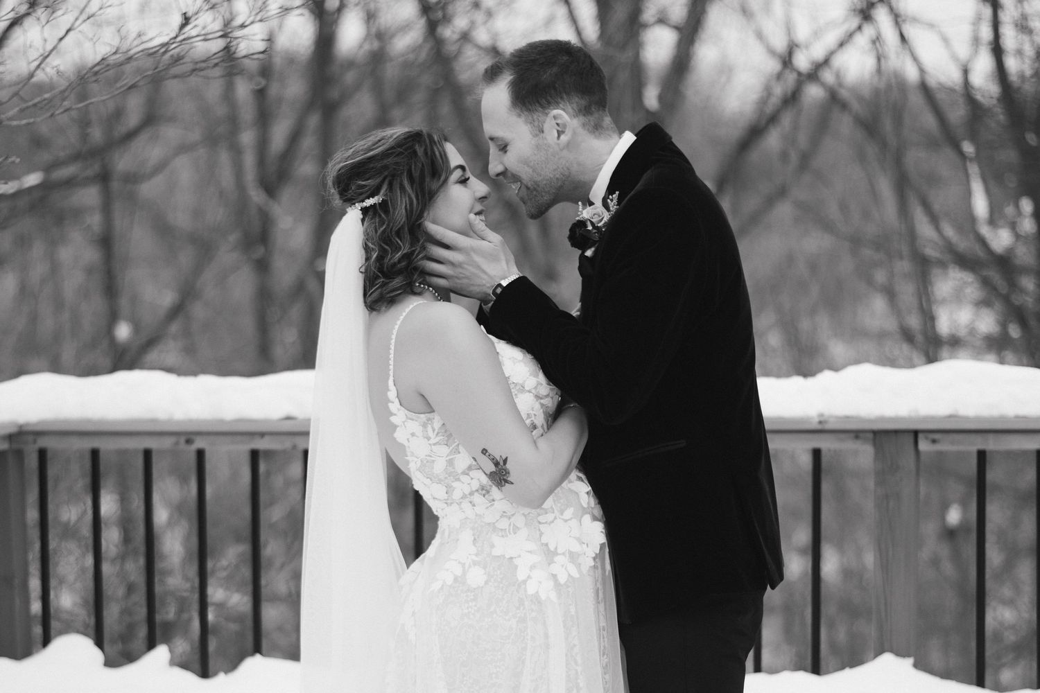A groom embracing his brides face post first look at Cambridge Butterfly Conservatory