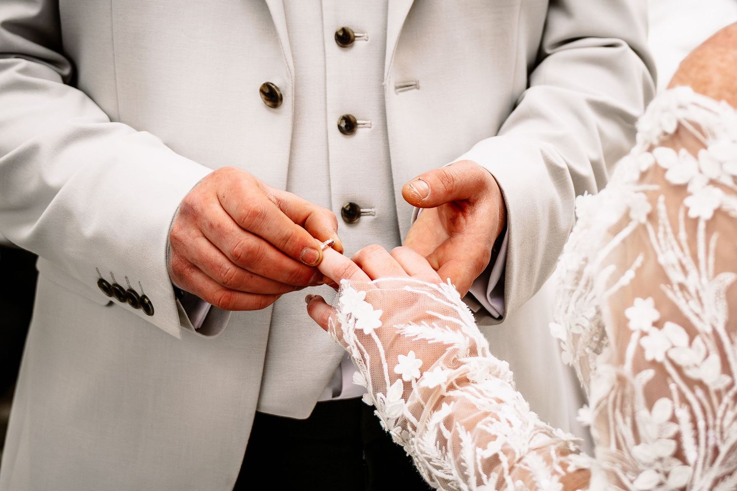 Close-up details of white wedding attire and delicate lace patterns.