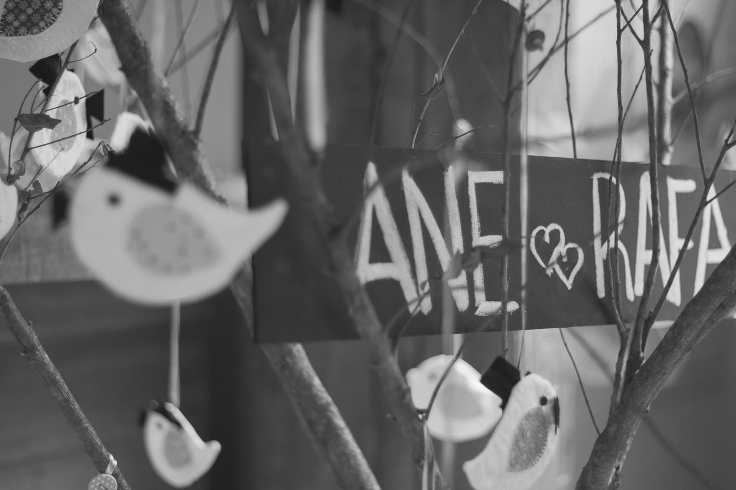 Black and white artistic detail of decorative birds and text at a wedding.
