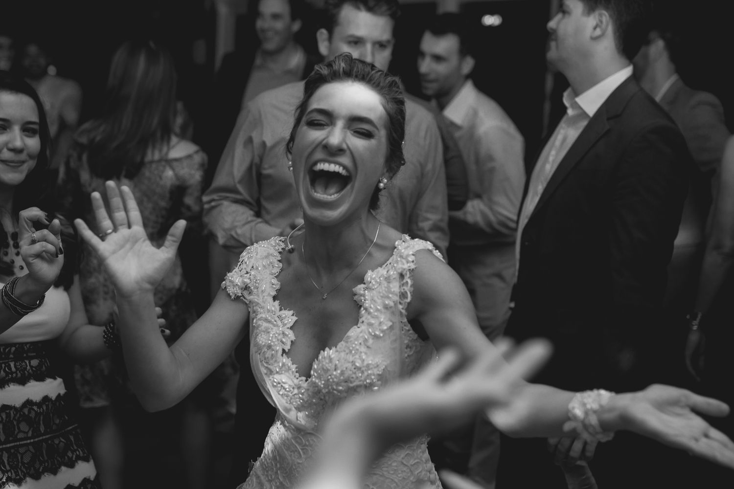 Black and white photo capturing pure joy and laughter during a wedding celebration.