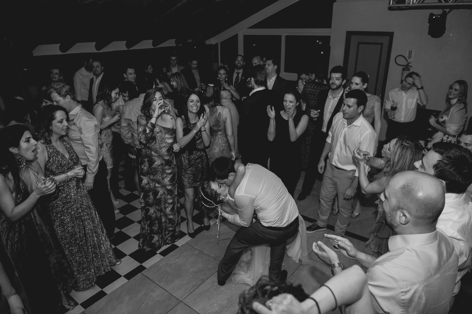 Wedding guests form a circle on the dance floor during an energetic reception celebration.