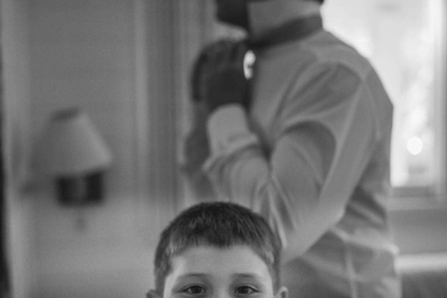 A candid black and white photograph captured during wedding preparations.