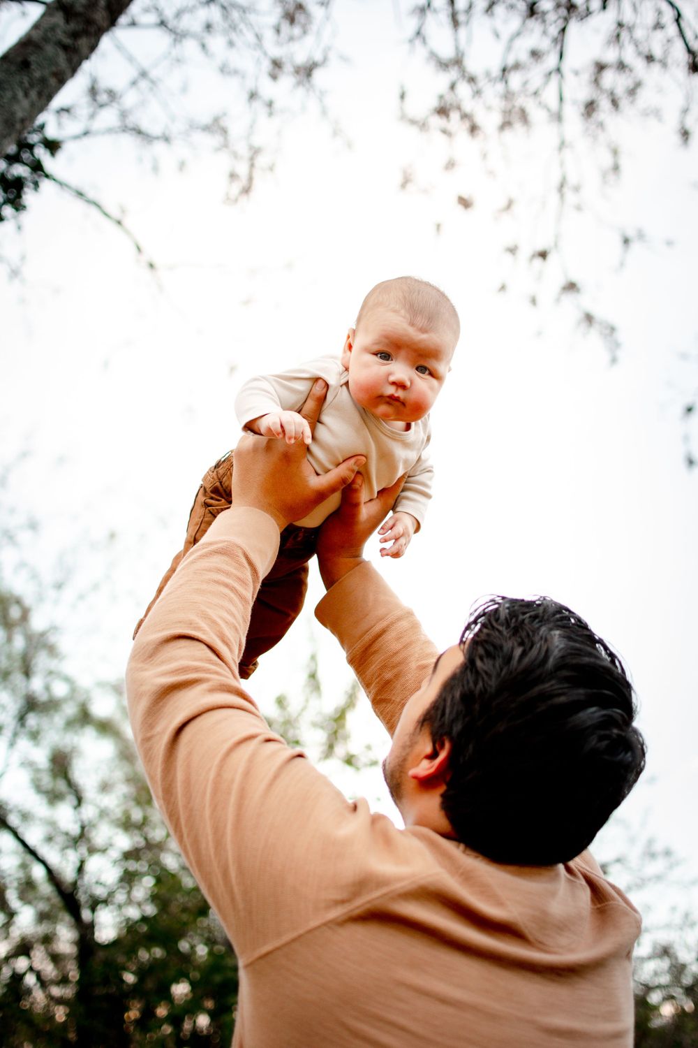 father holding up his son during an outdoor lifestyle family session in DFW