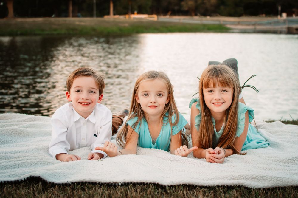 siblings pose together on a blanket for an outdoor Fort Worth family session in North Texas