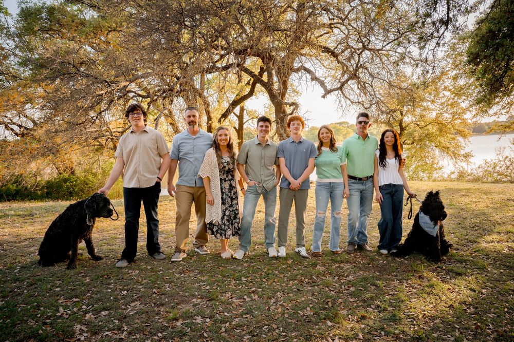 Large family group standing outdoors with dogs at a Weatherford lake during a Dallas–Fort Worth family photo session