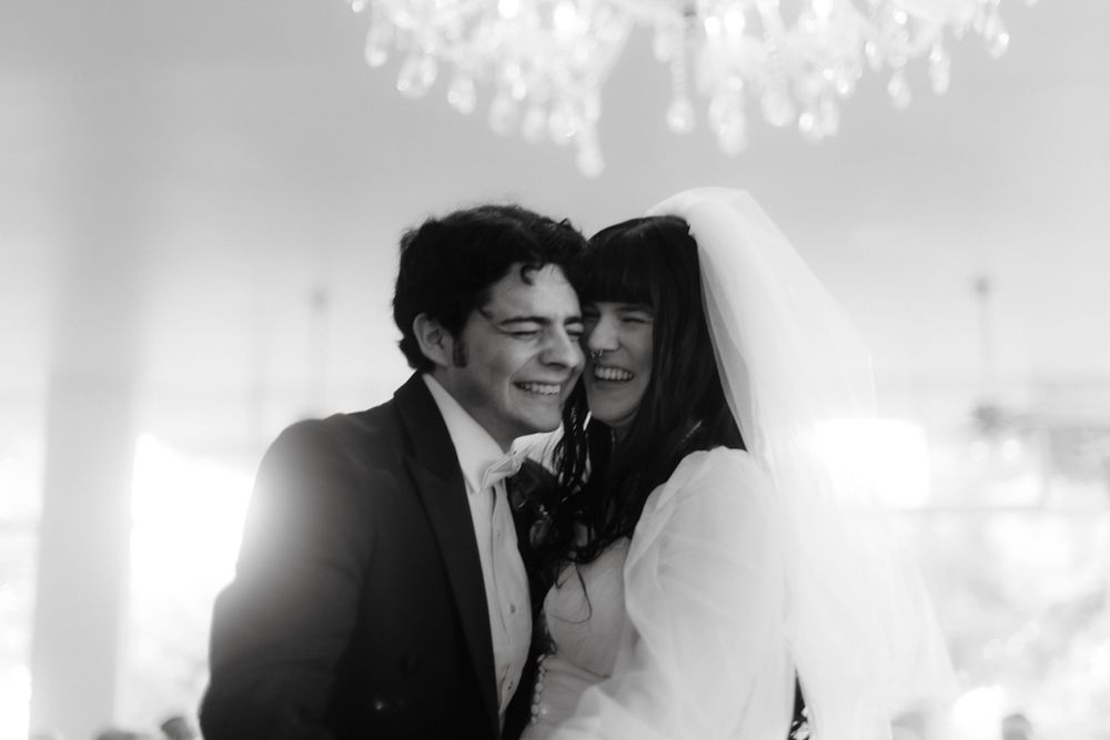 Intimate black and white wedding portrait under crystal chandelier.