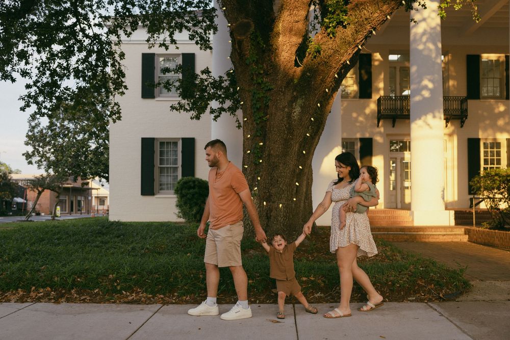 Five small LED lights wrapped around tree trunks illuminate a walkway at dusk creating a warm evening ambiance.