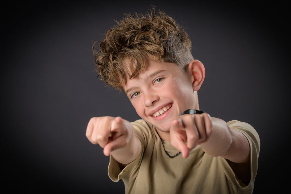 Multiple poses of a child making silly expressions against a dark background.