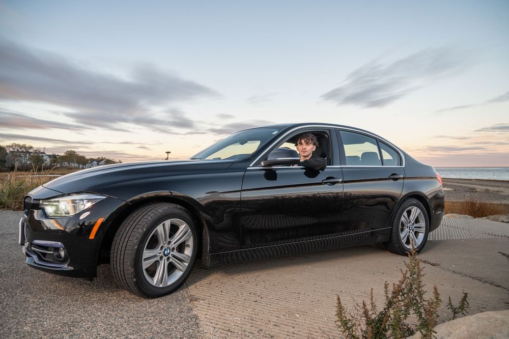 A sleek black luxury car photographed in multiple angles against scenic backgrounds during sunset.