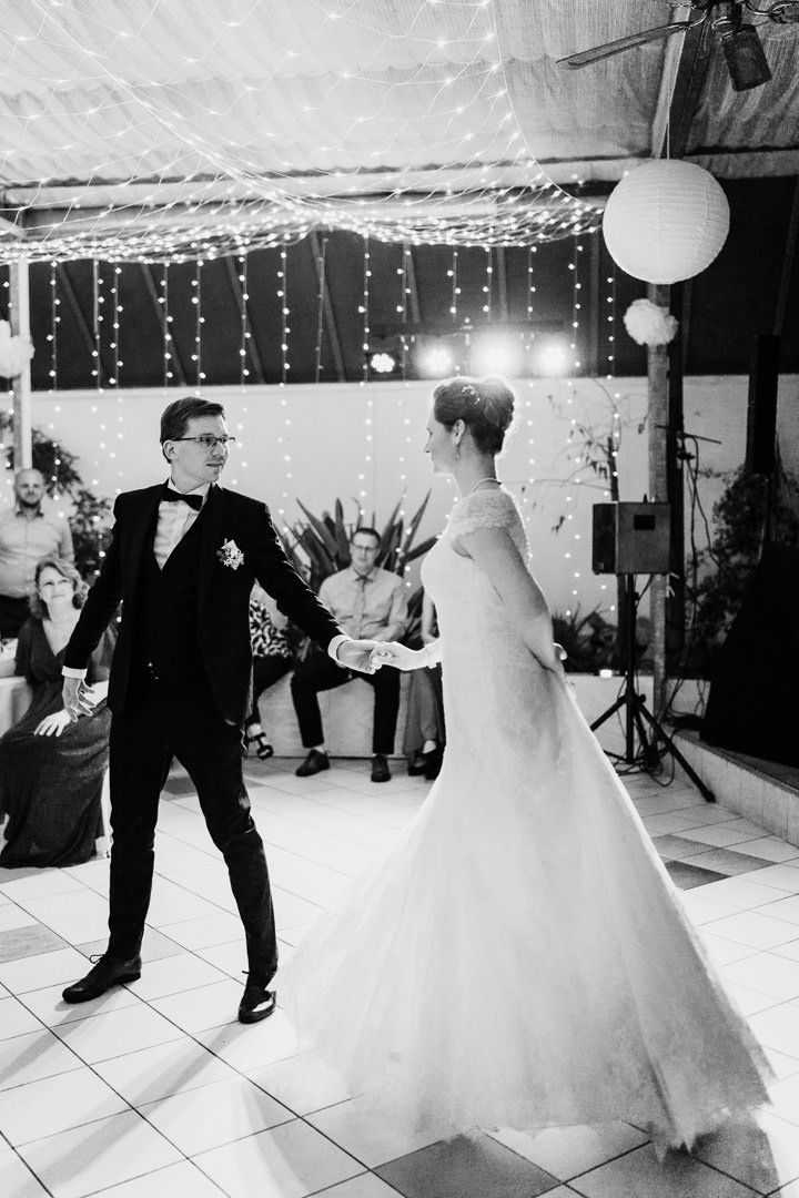Black and white photo showing energetic dance moves during wedding reception.
