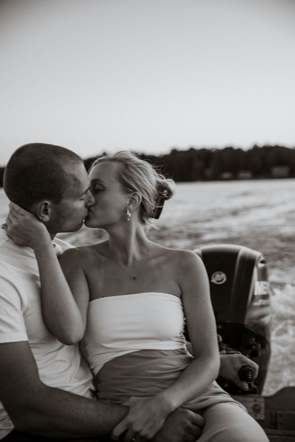 A romantic black and white portrait captured at sunset by the water.