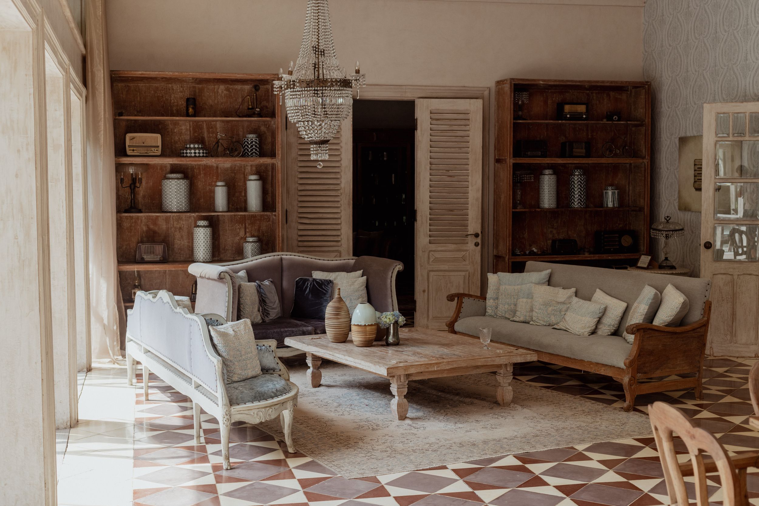 Vintage-style living room with wooden furniture, built-in shelves and cream-colored decor.