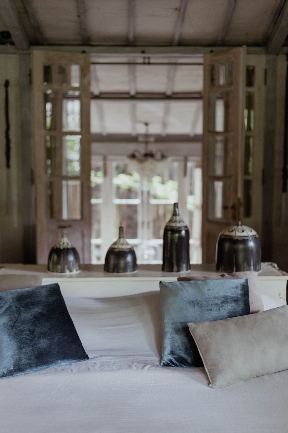 Cozy bedroom interior with soft cushions and vintage bell jar lights on display.