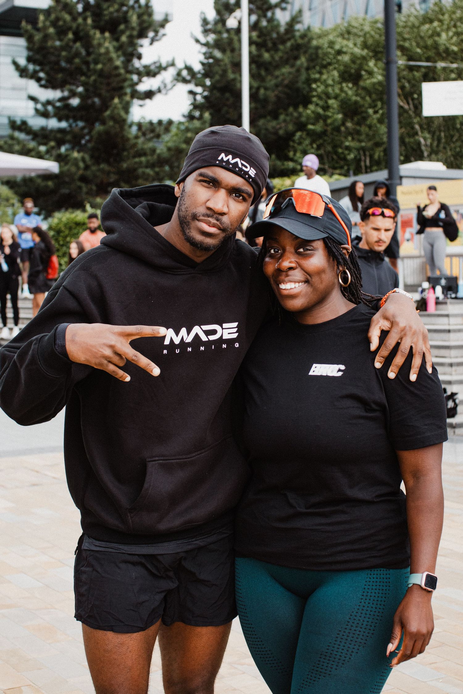 Herman Dange, founder of MADE Running poses and smiles with his friend wearing matching black MADE sportswear.