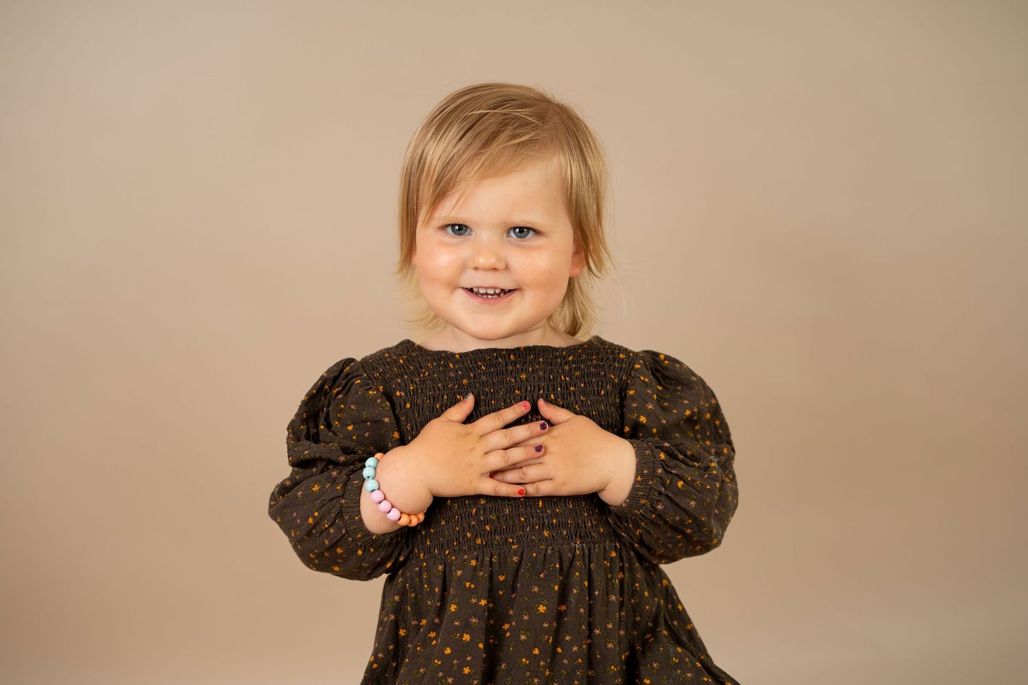 Barnefotograf Sandnes - Blid toåring på barnefotografering i studio med beige bakrgunn