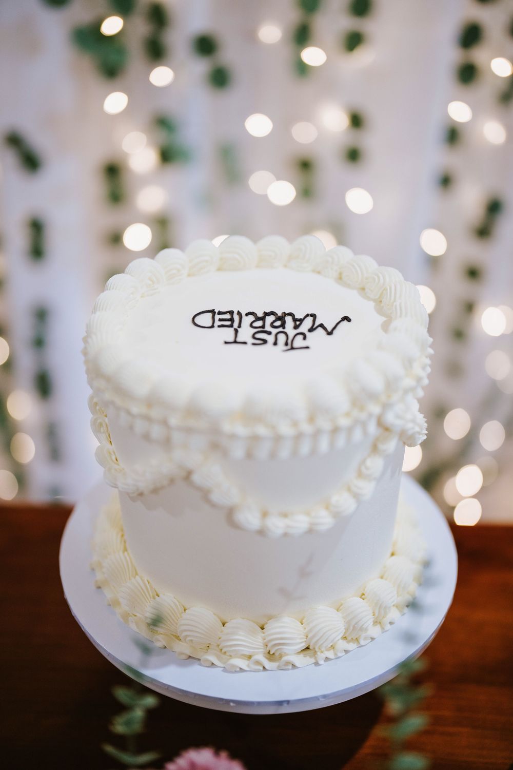 White wedding cake with gold topper at a South Asian wedding reception in Sydney