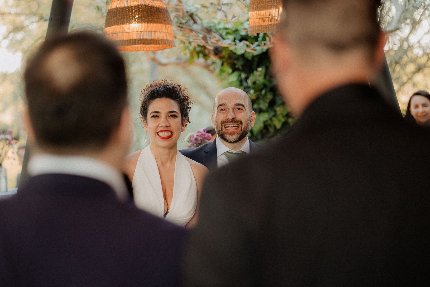 Antonio e Silvia sorridono durante la festa, incorniciati dagli invitati.