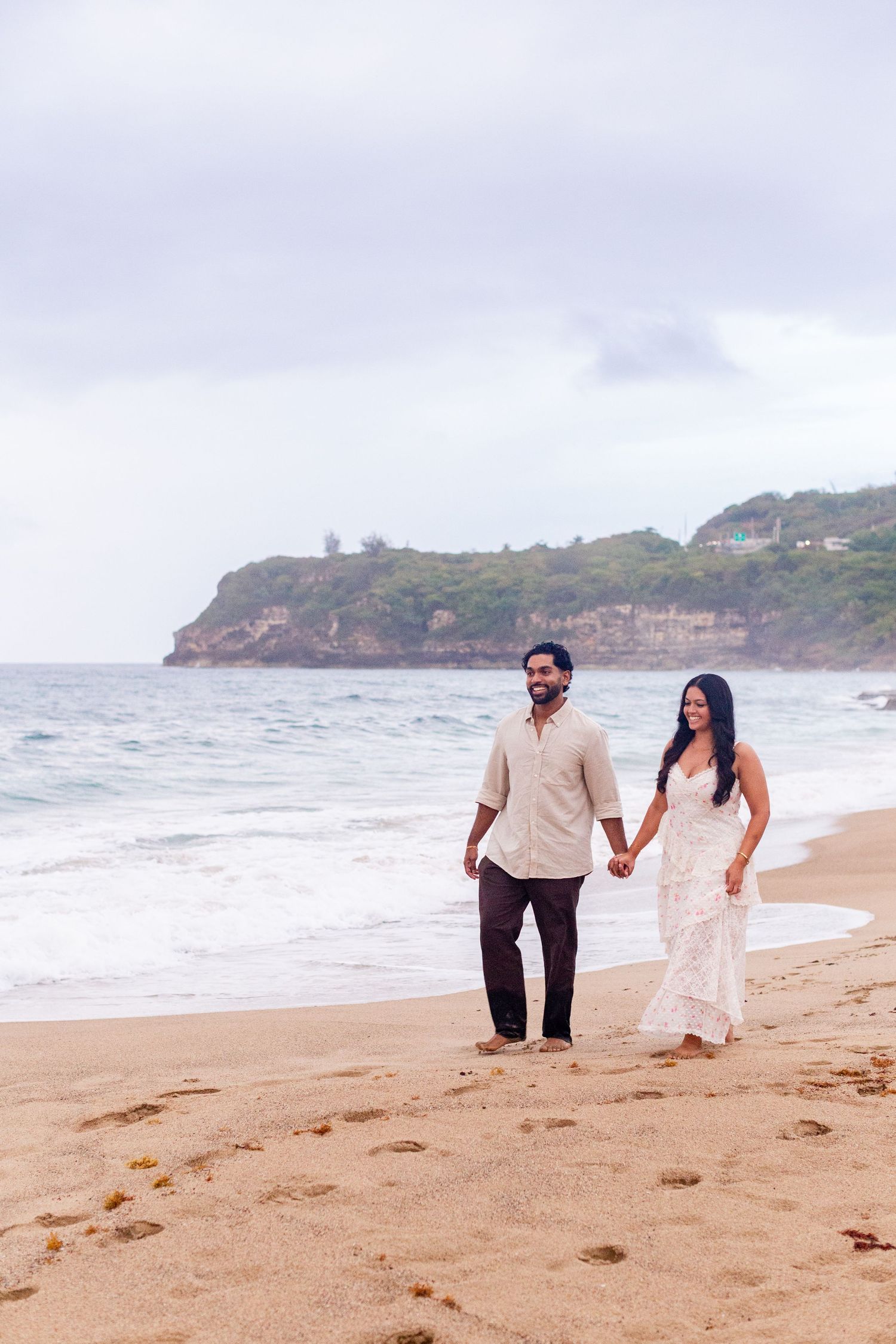 Engagement portrait. Man and woman walking on the beach. Playa Guajataca, Isabela, Puerto Rico.