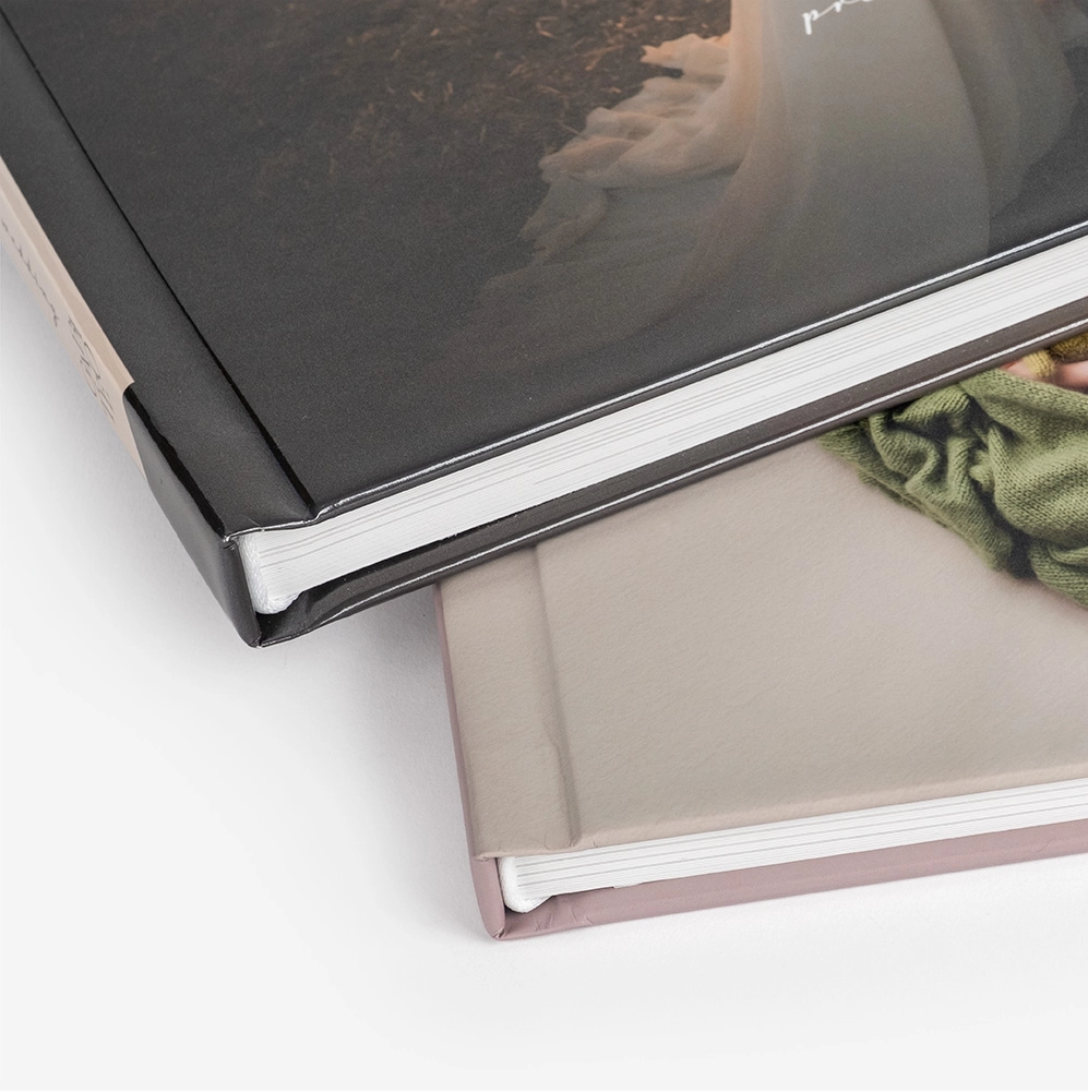 Stacked photo albums with black and neutral covers photographed from above.