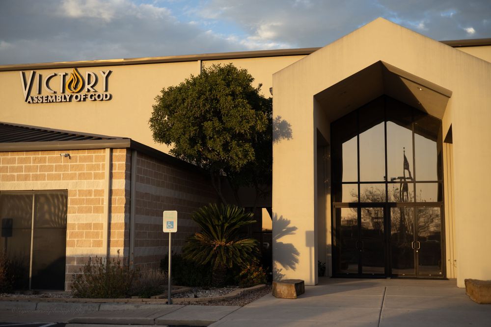 Exterior view of Victory Assembly of God church building at sunset with modern architecture.
