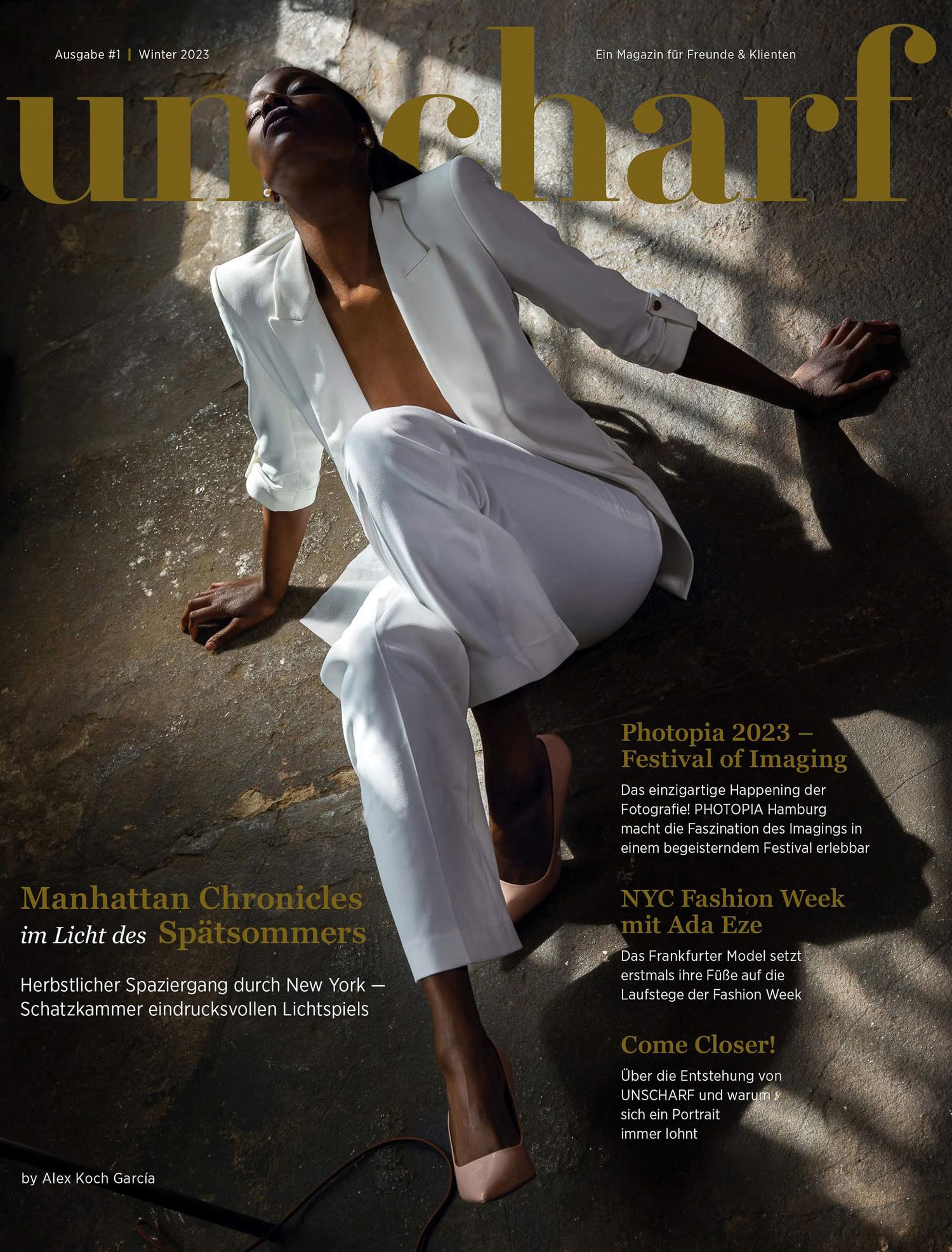 Magazine cover of Unscharf featuring a model in white suit, with headlines about Manhattan Chronicles and NYC Fashion Week.