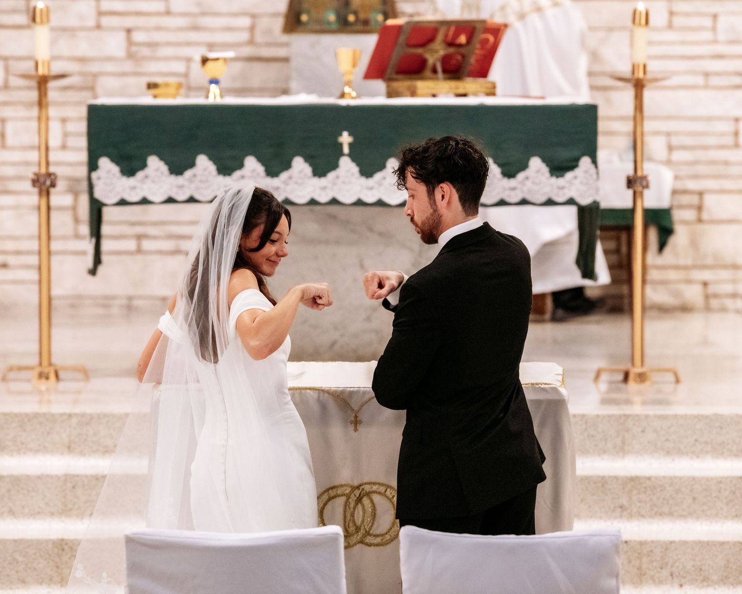Bride and groom exchanging rings at church altar during wedding ceremony.